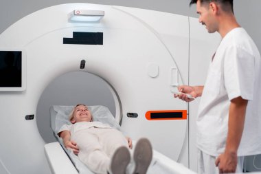 Modern bir klinikte, beyaz bir ofiste, MRI için bir ilaç, genç bir kızın beyninin incelenmesi, yıllık muayene