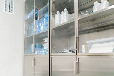 Modern bir klinikte, parlak, geniş ve temiz bir plastik cerrahi odasında, gerekli ekipmanlar, modern tıp, steril bir alan, ilaçlarla dolu bir dolap.