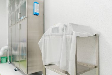 Modern bir klinikte, parlak, geniş ve temiz bir plastik cerrahi odasında, gerekli ekipmanlar, modern tıp, steril bir alan, ilaçlarla dolu bir dolap.