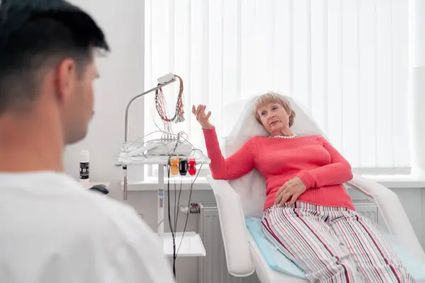 stock image in a modern clinic in a white office, a drug for checking heart rhythm, a cardiogram, a doctor listens to the patient s complaints