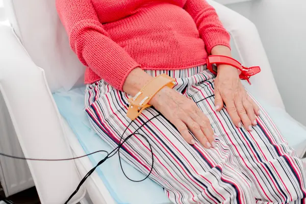 stock image close up in a modern clinic in a white office, a drug for checking heart rhythm, a cardiogram, a doctor diagnoses an elderly female patient