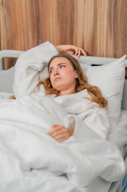 Modern bir klinikte, parlak bir VIP odasında, soğuk algınlığı olan beyaz önlüklü genç bir kız yatıyor.