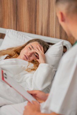 Modern bir klinikte, parlak bir VIP odasında, beyaz önlüklü genç bir kız hasta, bir doktorla görüşüyor, tedavi önerileri...
