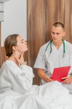 Modern bir klinikte, parlak bir VIP odasında, beyaz önlüklü genç bir kız hasta, bir doktorla görüşüyor, tedavi önerileri...