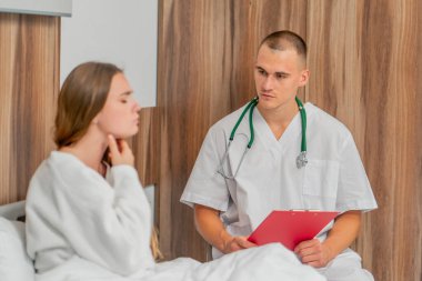 Modern bir klinikte, parlak bir VIP odasında, beyaz önlüklü genç bir kız hasta, bir doktorla görüşüyor, tedavi önerileri...