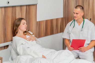 Modern bir klinikte, parlak bir VIP odasında, beyaz önlüklü genç bir kız hasta, bir doktorla görüşüyor, tedavi önerileri...
