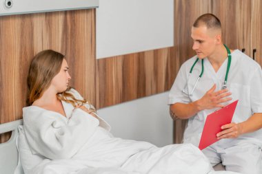 Modern bir klinikte, parlak bir VIP odasında, beyaz önlüklü genç bir kız hasta, bir doktorla görüşüyor, tedavi önerileri...