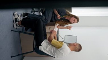 Modern bir klinikte, küçük bir terapistin ofisindeki dikey bir videoda, steteskoplu genç bir kız doktor, bir sorunu teşhis eden genç bir adamla randevusunu gerçekleştiriyor.