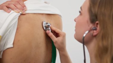 Modern bir klinikte, küçük bir terapistin ofisinde, steteskoplu genç bir kız doktor, genç bir hastayla randevu ayarlar, bir sorunu teşhis eder, akciğerleri dinler.