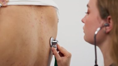 Modern bir klinikte, küçük bir terapistin ofisinde, steteskoplu genç bir kız doktor, genç bir hastayla randevu ayarlar, bir sorunu teşhis eder, akciğerleri dinler.