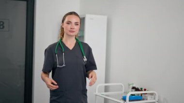Modern bir klinikte, küçük bir terapistin ofisinde, kırmızı klasör test sonuçlarıyla genç bir doktor, sonuçların değerlendirilmesi, genç ve mutlu bir uzman kameraya bakar.