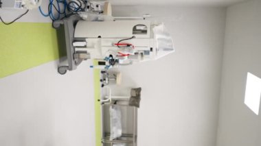 Modern bir klinikte, parlak, geniş ve temiz bir estetik ameliyat odasında, gerekli ekipmanlar, modern tıp, steril bir alan, ilaçlı bir dolap...