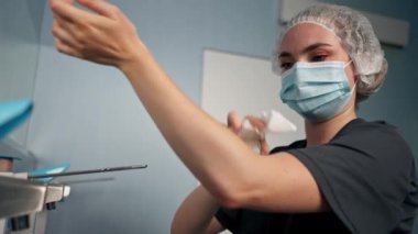 Cerrahların ellerini sterilize etmek için geniş bir alanda modern bir klinikte kadın cerrah ellerini iyice yıkıyor.