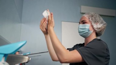 Cerrahların ellerini sterilize etmek için geniş bir alanda modern bir klinikte kadın cerrah ellerini iyice yıkıyor.