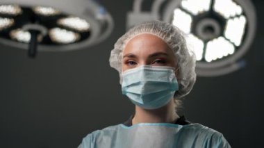 Çağdaş bir klinikte, parlak, geniş bir ameliyathanede, cerrah ameliyatı yapmak için tamamen hazırdır.