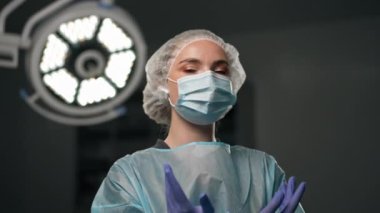 Çağdaş bir klinikte, parlak, geniş bir ameliyathanede, cerrah ameliyatı yapmak için tamamen hazırdır.