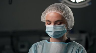 Çağdaş bir klinikte, parlak, geniş bir ameliyathanede, cerrah ameliyatı yapmak için tamamen hazırdır.