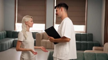 Modern bir klinikte, bekleme odasında, hafif elbiseli genç bir kız, sonuçlarla doktora yaklaşır ve sağlık sorunu hakkında konuşur.