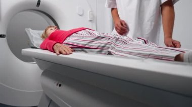 Modern bir klinikte, beyaz bir ofiste yaşlı bir kadının, yakınlardaki genç bir doktorun beyin MR 'ı için bir ilaç.