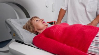 Modern bir klinikte, beyaz bir ofiste yaşlı bir kadının, yakınlardaki genç bir doktorun beyin MR 'ı için bir ilaç.