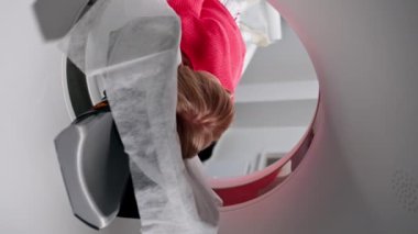 Beyaz bir ofisteki modern bir klinikte, yaşlı bir kadının beyninin MRI incelemesi için kullanılan bir ilaç, prosedürü başlatır.