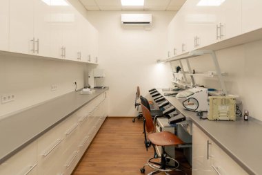 Diş protezleri üretimi için profesyonel laboratuvar kaplamalar müşterilere diş üretmek için ekipman ve masalar ile çalışır