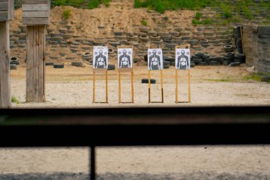 Profesyonel bir atış poligonunda, kumlu bir alanda, hedeflerin yanında duruyor, iyi bir mesafede, profesyonel bir atış poligonu, eğitimli askerler.