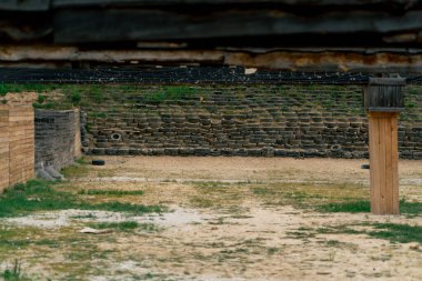 Profesyonel bir atış poligonunda, kumlu bir zeminde, araba lastiklerinden yapılmış çitler, profesyonel bir atış poligonu, eğitim askerleri, koruyucu ahşap duvarlar