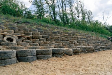 Profesyonel atış poligonunda, kumlu zemin, araba lastiklerinden yapılmış eskrim, profesyonel atış poligonu, askerleri eğitmek, kurşun korumalı ahşap duvarlar.