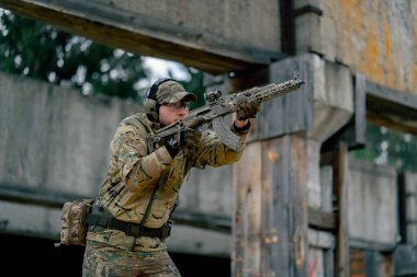 Bir duvarın altından NATO tüfek talimi için askeri taktik stratejisi. Profesyonel bir atış talimi. Askeri üniforma hazırlığında ilk brifing eğitmeni.