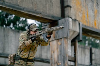 Bir duvarın altından NATO tüfek talimi için askeri taktik stratejisi. Profesyonel bir atış talimi. Askeri üniforma hazırlığında ilk brifing eğitmeni.