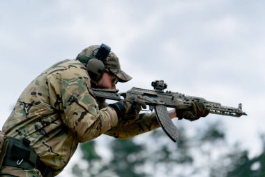 Bir duvarın altından NATO tüfek talimi için askeri taktik stratejisi. Profesyonel bir atış talimi. Askeri üniforma hazırlığında ilk brifing eğitmeni.