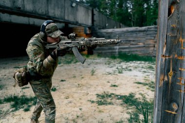 Bir duvarın altından NATO tüfek talimi için askeri taktik stratejisi. Profesyonel bir atış talimi. Askeri üniforma hazırlığında ilk brifing eğitmeni.