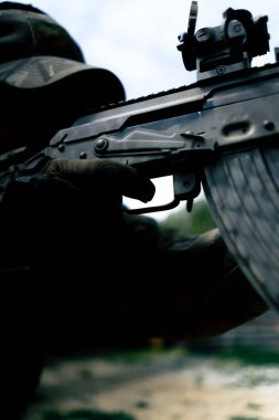 Yakın plan askeri taktik NATO tüfek eğitimi profesyonel bir atış menzilinde. Askeri üniformalı eğitmen tetiği çeker.