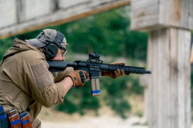 NATO tüfek taliminden hedeflenen askeri taktik stratejisi profesyonel bir atış poligonuna nişan alınıyor. Askeri üniforma hazırlığında ilk brifing eğitmeni.