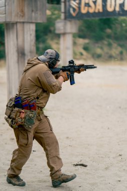 Askeri strateji tüfeği atış pozisyonu askeri üniformalı bir atış poligonu eğitmenine atletizm eğitimine devam ediyor.