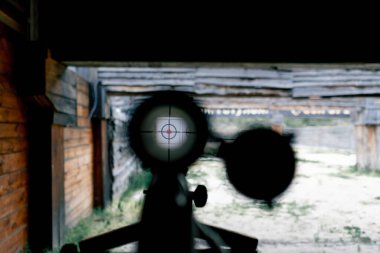 Profesyonel atış poligonuna yakın plan geniş kalibreli görüş hedefe yönelik atış taliminin uzun mesafeli isabet hassasiyetini hedefliyor.