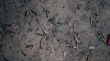 Profesyonel bir atış poligonunda kumlu bir yüzeyde farklı kalibrelerde birkaç şarjör bulunan makineli tüfekten çıkan boş mermiler kullanılmış.