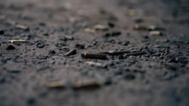 Profesyonel bir atış poligonunda kumlu bir yüzeyde farklı kalibrelerde birkaç şarjör bulunan makineli tüfekten çıkan boş mermiler kullanılmış.