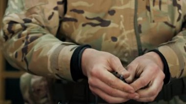 Profesyonel bir atış poligonunda, bir ağaç standında, bir antrenör Amerikan makineli tüfeğinin sökülmesi ve temizlenmesi hakkında talimatlar verir.