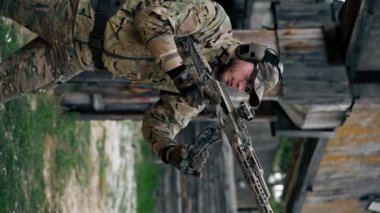 NATO tüfek taliminden hedeflenen dikey video askeri taktik stratejisi profesyonel bir atış poligonuna nişan alınıyor. Askeri üniforma hazırlığında ilk brifing eğitmeni.