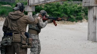 NATO tüfek taliminden hedeflenen askeri taktik stratejisi profesyonel bir atış poligonuna nişan alınıyor. Askeri üniforma hazırlığında ilk brifing eğitmeni.