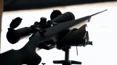 Profesyonel atış poligonunda, ahşap masadaki profesyonel tüfek, geniş kalibreli av tüfeği, modern savaş teknolojisi.