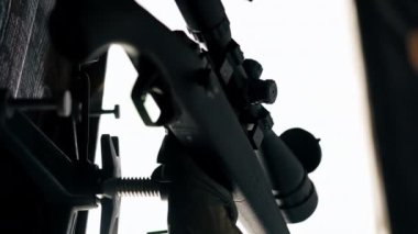 Profesyonel atış poligonunda, ahşap masadaki profesyonel tüfek, geniş kalibreli av tüfeği, modern savaş teknolojisi.