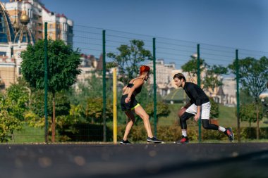 Spor sahası basketbol sahasında kısa şortlu, sarı tişörtlü basketbol oynayan siyah saçlı kız basketbol oynuyor.