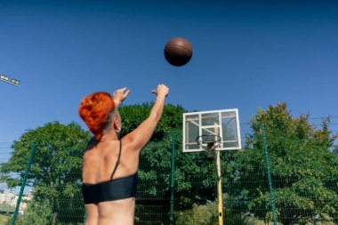 Spor sahasında kısa saçlı, şortlu, siyah tişörtlü ve çeviklik konusunda basketbol antrenmanına giden kızı kapatın.