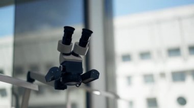 Ayrıntılı çalışma için mikroskop ekipmanı üzerinde diş kaplaması ve taç büyüteç üretimi için yakın plan profesyonel laboratuvar