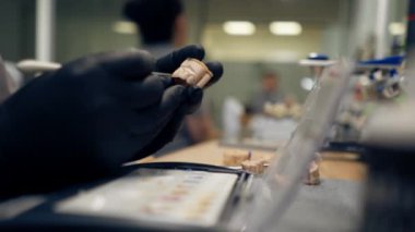 Diş protozoası ve kaplama üretimi için profesyonel laboratuarı kapatın. Uzman, müşterinin dişlerinin altında diş minesi kaplamalı boyalarla oturur.