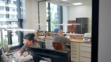 Diş protezleri üretimi için büyük, profesyonel bir laboratuvar. Kaplamalar, müşteriler için diş üretmek için ekipman ve masalar. Büyük bir ekip.