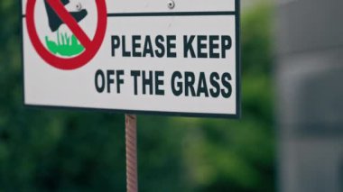 Kentsel yaz manzarası şehir merkezinin avlu tabelasını kapatın. Çimlerin üzerinde yürümemenizi yasaklayan çim illüstrasyonuna dikkat edin.